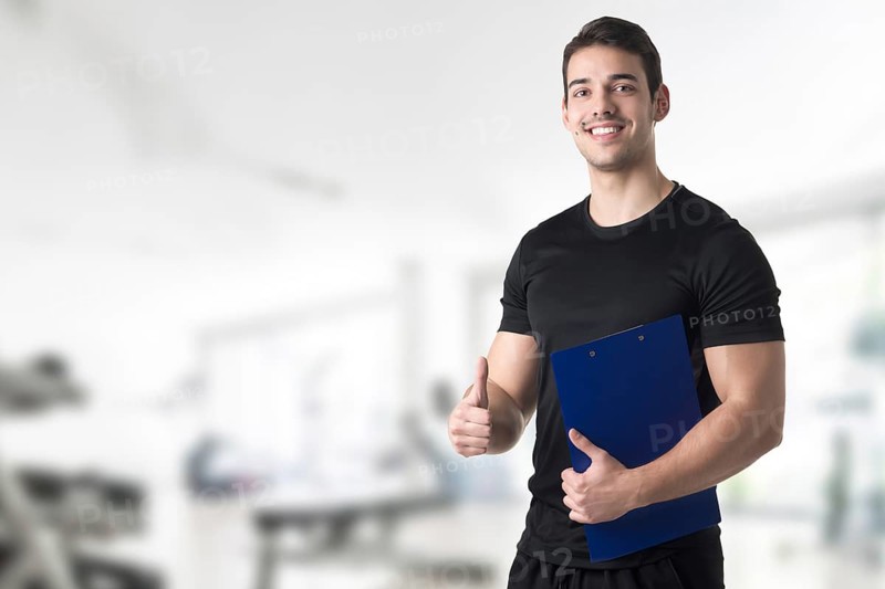 Personal trainer in a gym holding a notepad