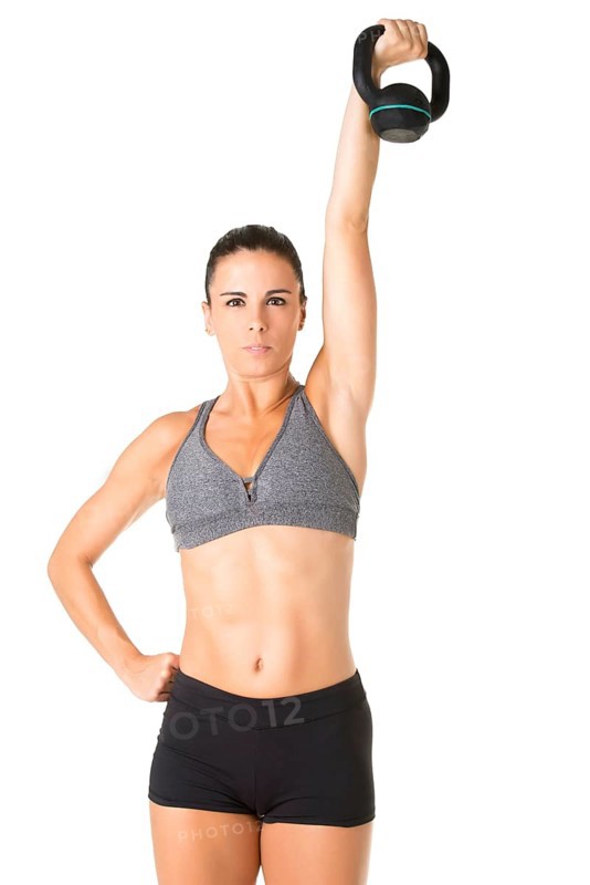 Fit woman working out with a kettlebell, isolated in white