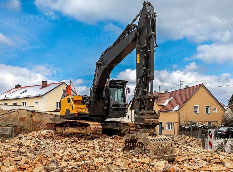Excavator on the rubble of a demolished building