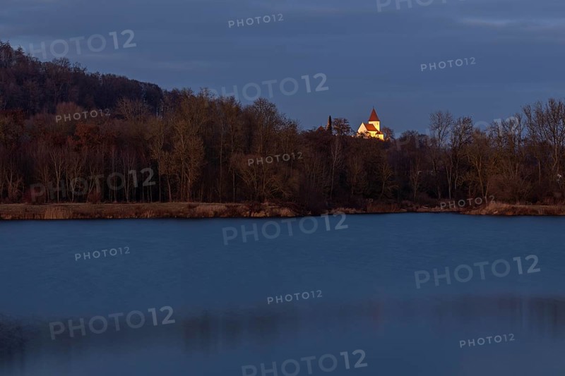 Illuminated church of Schaefstall near Donauworth above a lake in Bavaria