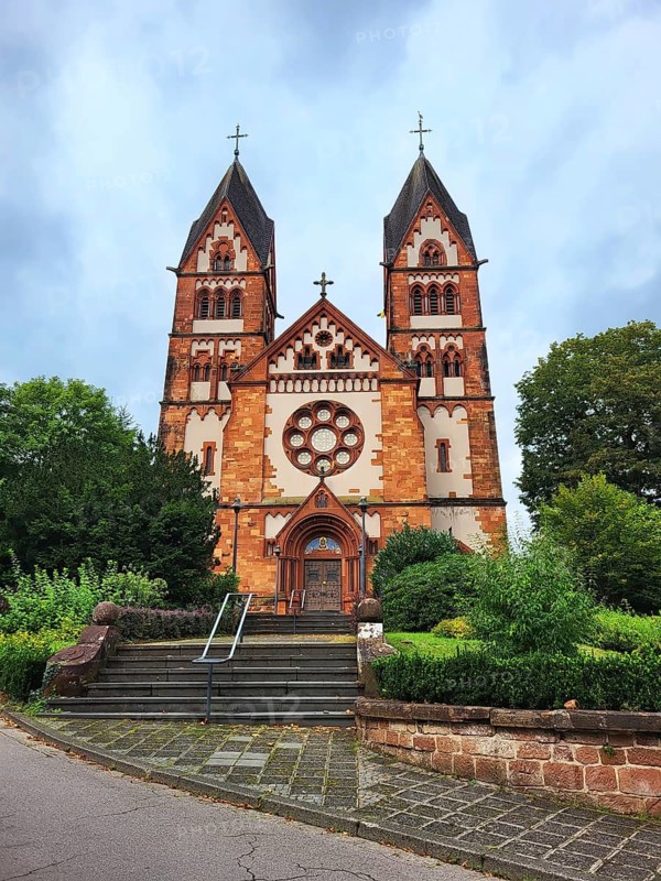 St Lutwinus Church in Mettlach is a Catholic parish church built in the neo-Gothic style. The church has two towers and a rose window. Mettlach, Merzig-Wadern, Saarland, Germany, Europe