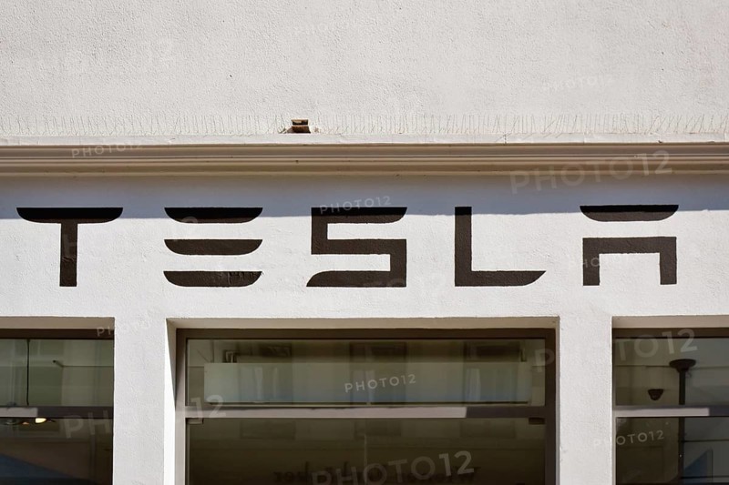 Heidelberg, Germany, June 28th 2024: Tesla electric car brand logo above showroom store in city center, Europe