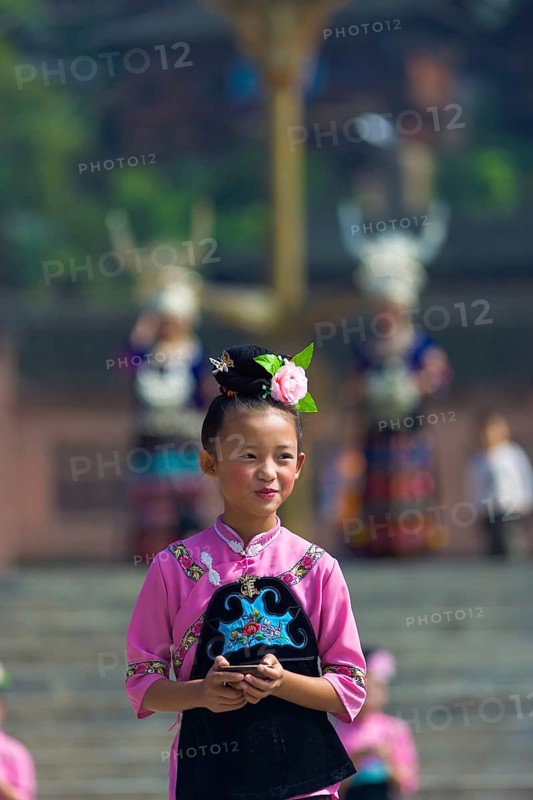 Xijiang, China, September 15, 2007: An Miao ethnic minority girl dressed in pink and black performing at a local festival at the traditional Miao village of Xijiang, Guizhou, China, Asia