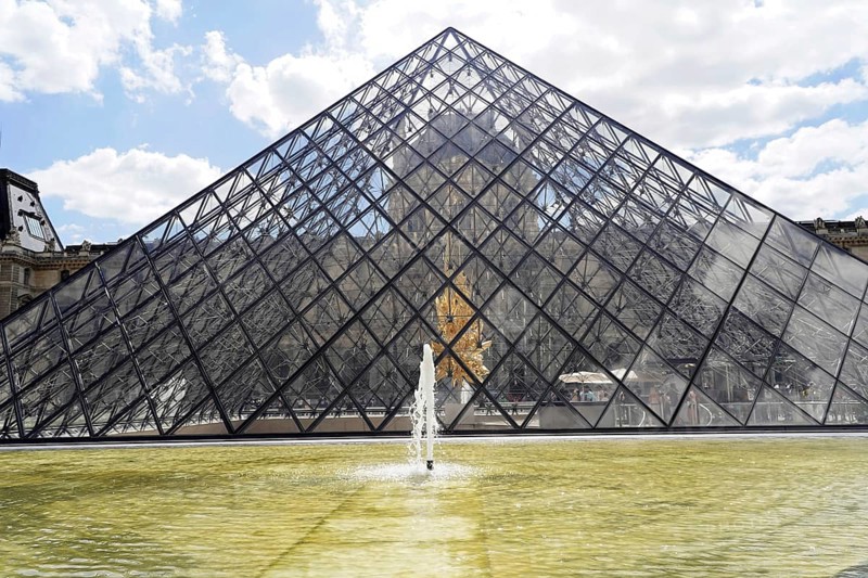 Glass pyramid in the courtyard of the Palais du Louvre, Paris, France, Europe, Glass pyramid of the Louvre in Paris, reflected in the water basin, under a blue sky with clouds, Europe