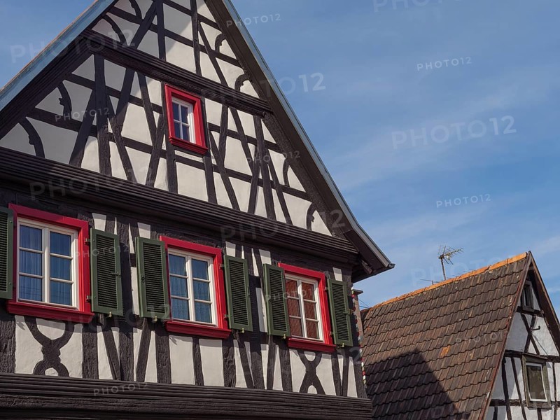 Two historic half-timbered houses with windows and colourful shutters under a blue sky, Kandel, Palatinate, Germany, Europe