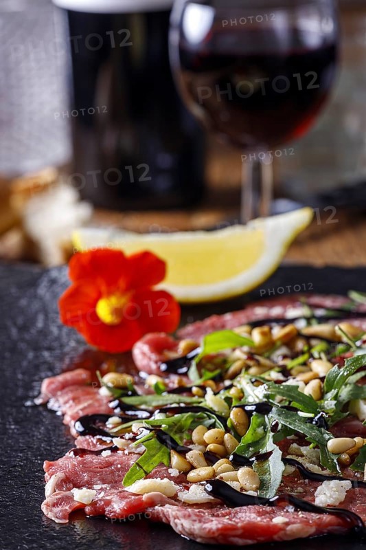 Fresh carpaccio with rocket on slate