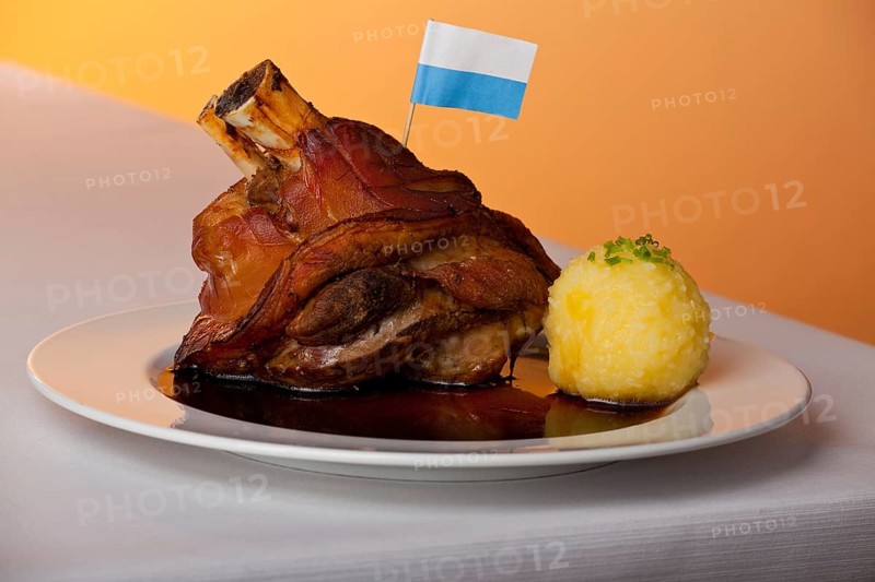 Pork knuckle with potato dumplings on a plate