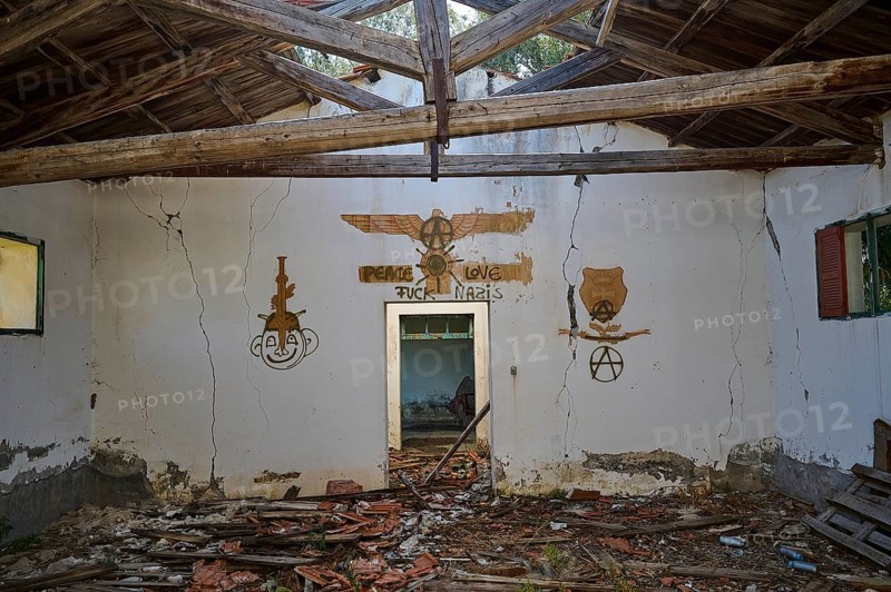 The wall of an abandoned building is covered with a peace message and several anarchy symbols, surrounded by dirt and bricks, Lost Place, World War II bunker, Barrack, Kalavarda, Rhodes, Dodecanese, Greek Islands, Greece, Europe