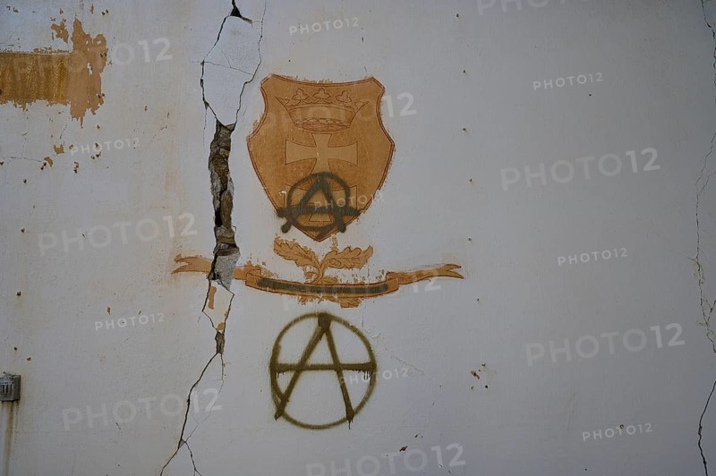 On a cracked white wall in an abandoned building, coats of arms and anarchy symbols can be seen as graffiti, Lost Place, World War II bunker, barrack, Kalavarda, Rhodes, Dodecanese, Greek Islands, Greece, Europe