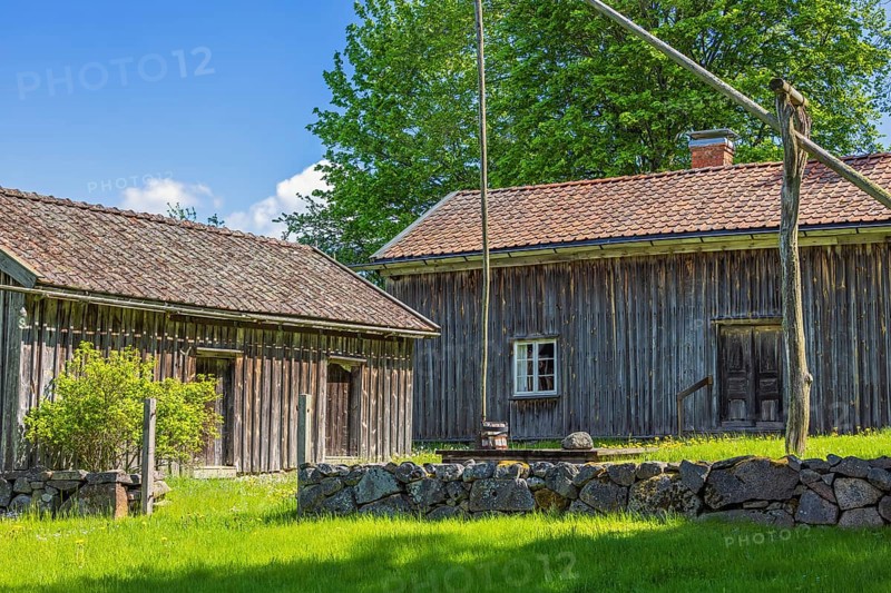 Rustic old farm with wooden house a water well and a stone wall in the swedish countryside, Suntak, Tidaholm, Sweden, Europe