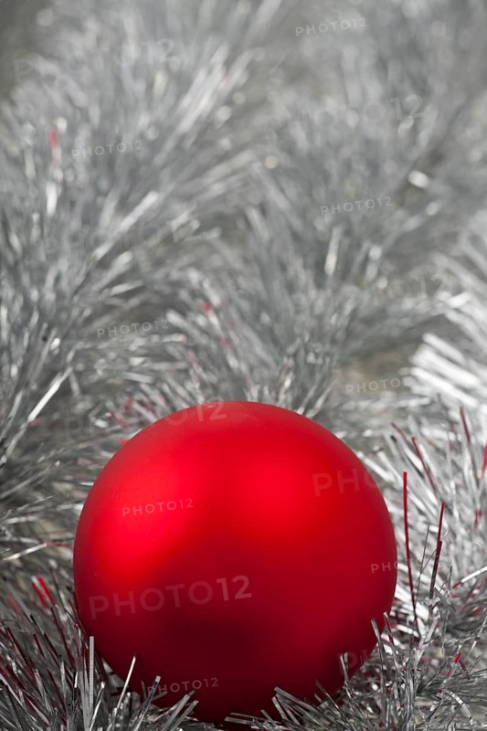 Red Christmas bauble on silver tinsel