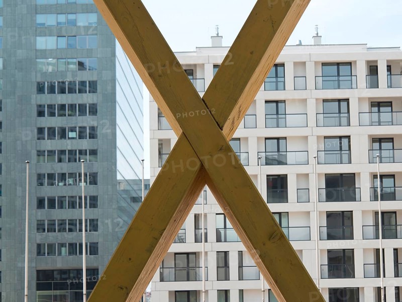 X-shaped timber constructions in front of a modern office building with large windows, Vienna, Austria, Europe