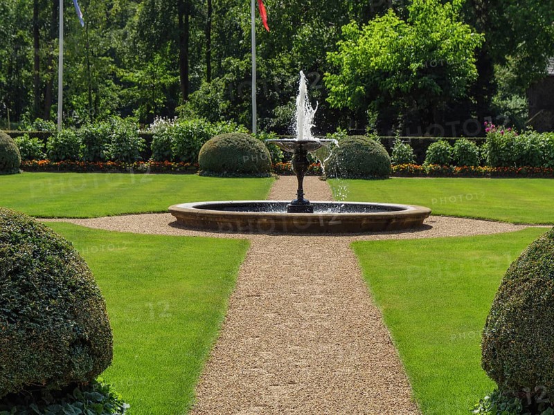 A well-tended garden with a bubbling fountain in the centre on a summer's day, ochtrup, münsterland, germany