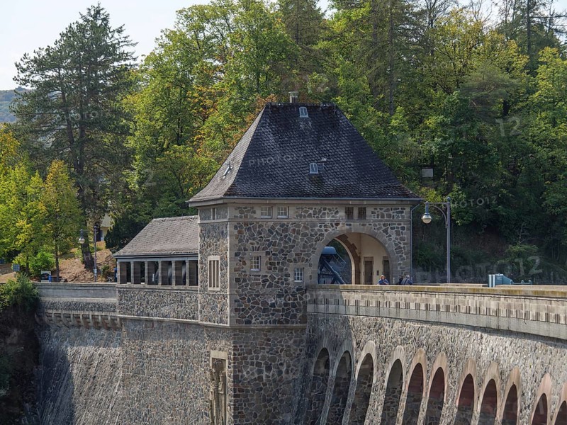 A dam with a historic stone building, surrounded by forest and trees, with a road and bridge lamps, Waldeck, Hesse, Germany, Europe