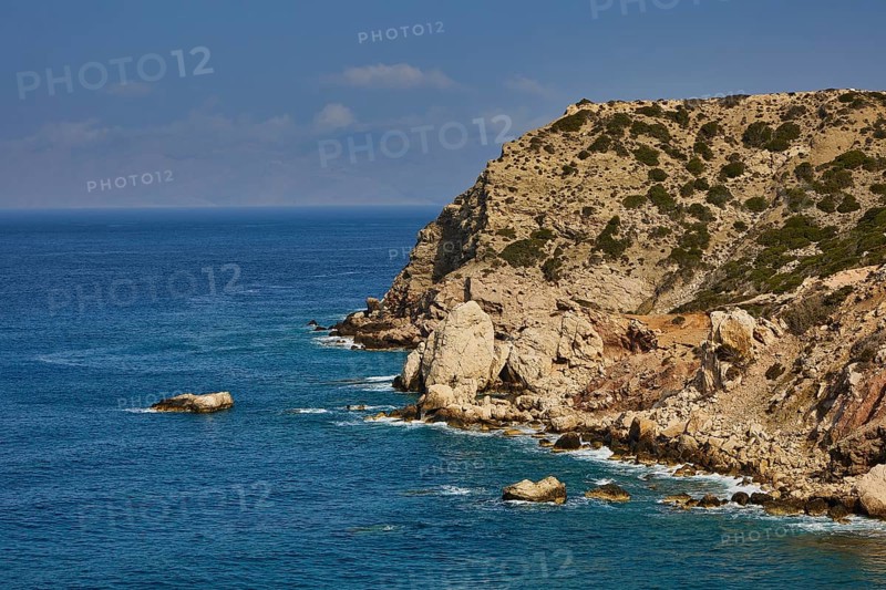 Cliff landscape by the sea with blue water and cloudy sky, Atavyros beach, near Monolithos village, Rhodes, Dodecanese, Greek Islands, Greece, Europe