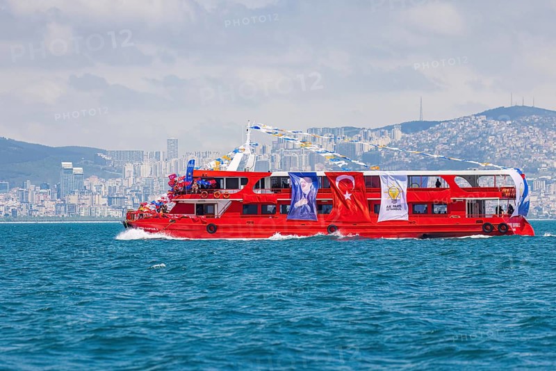 Supporters of the ruling AK party waving turkish flags on a red boat before presidential elections