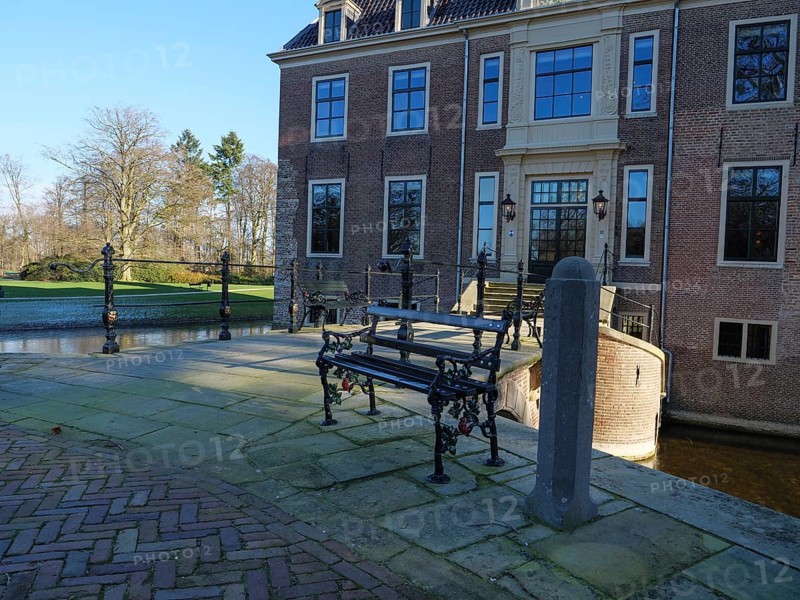 Bench in front of the entrance area of a historic castle, with cobblestones and a quiet atmosphere, ruurlo, gelderland, the netherlands