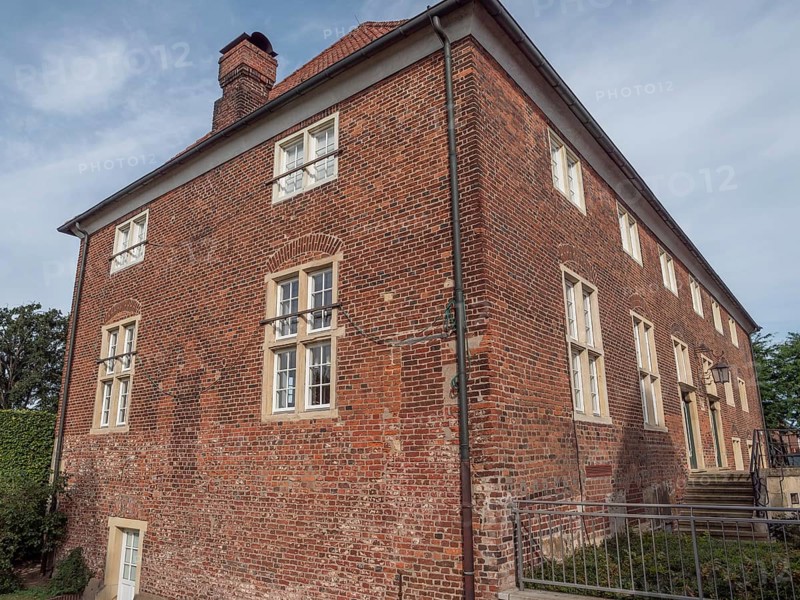 Large, two-storey brick building with many windows and a chimney under a cloudy sky, ramsdorf, münsterland, Germany, Europe