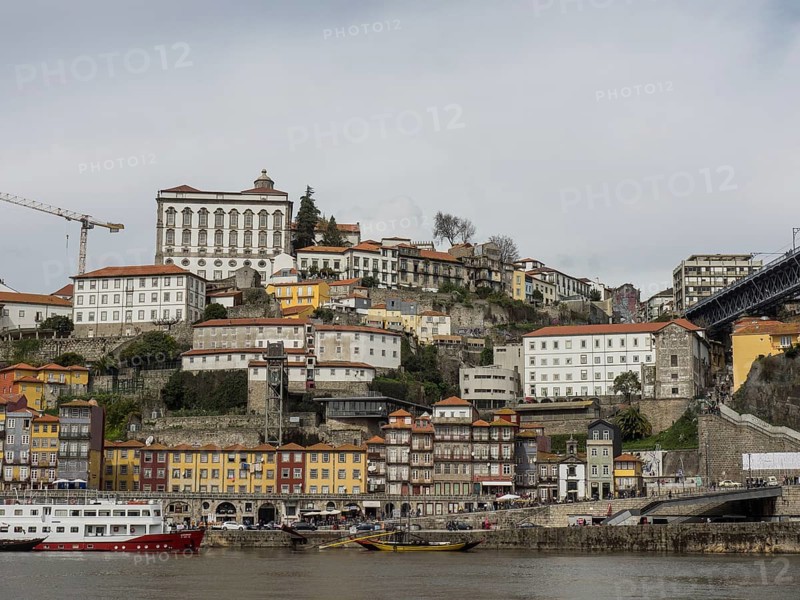 Riverside buildings stretch up the slopes of a hill, with overhanging cloud cover, Porto, Douro, Portugal, Europe