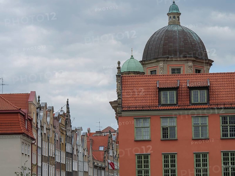Historic city buildings with striking domes and tiled roofs under a cloudy sky, Gdansk, Poland, Europe