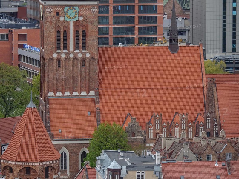 Brick church tower against a backdrop of modern architecture and skyscrapers, Gdansk, Poland, Europe