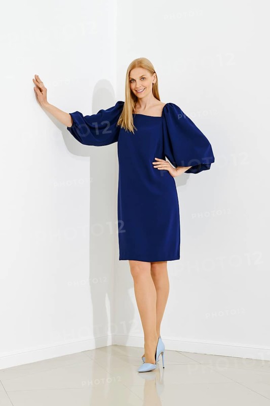 Full length portrait of smiling woman in dress with flounce sleeves