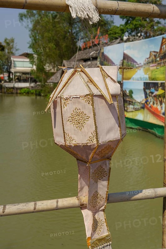 Traditional Chinese lantern with golden decorations, hanging from a bamboo pole over water, Pattaya, Thailand, Asia
