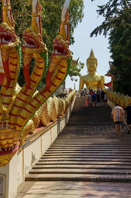 Golden Buddha statue at the top of a wide staircase, flanked by golden dragon figures, Pattaya, Thailand, Asia