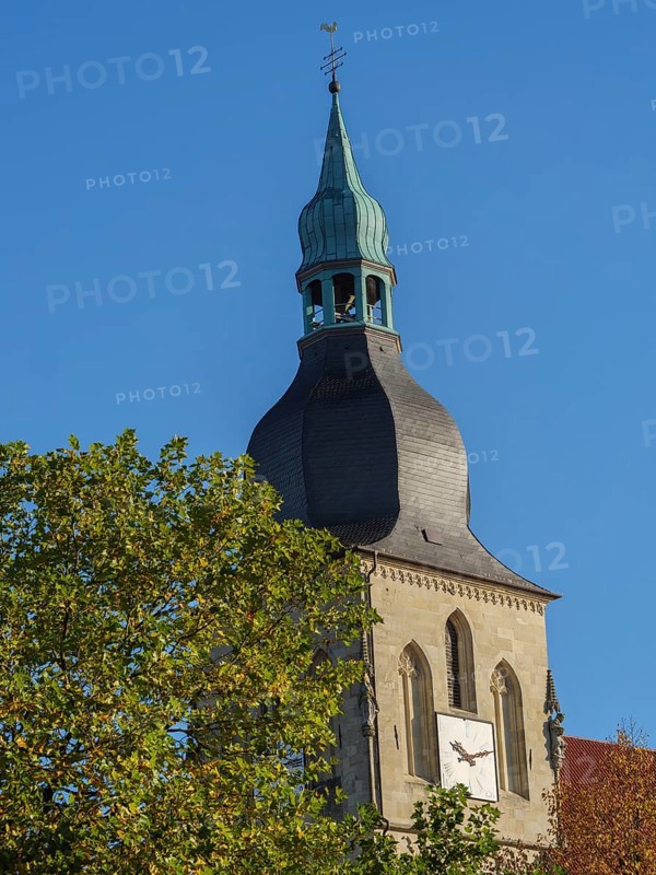 Close-up of a church tower with a clock and green dome in front of a blue sky, nottuln, münsterland, germany