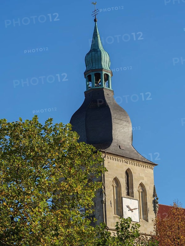 Close-up of a church tower with a clock and green dome in front of a blue sky, nottuln, münsterland, germany