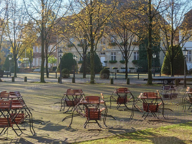 Deserted square in autumn with tables and chairs lined up under trees, nottuln, münsterland, germany