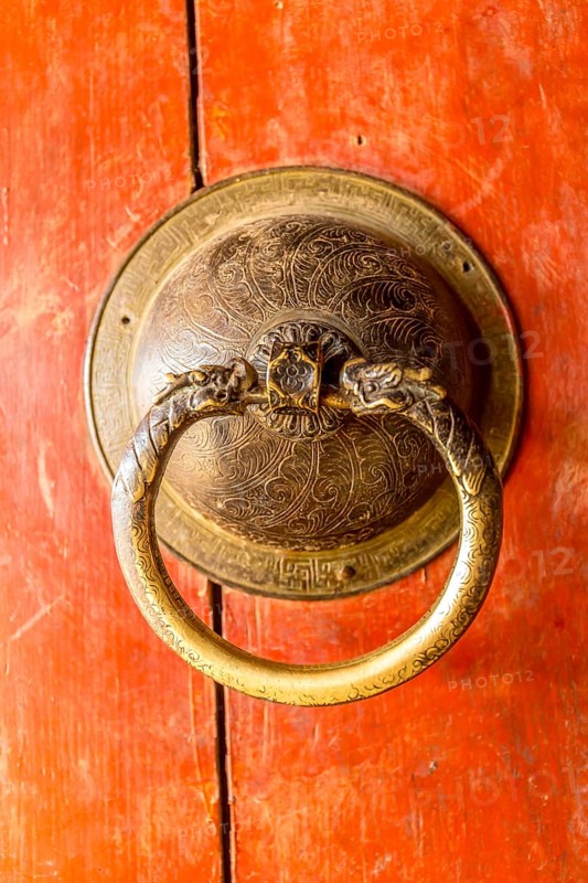 Golden door knob on a red wooden door