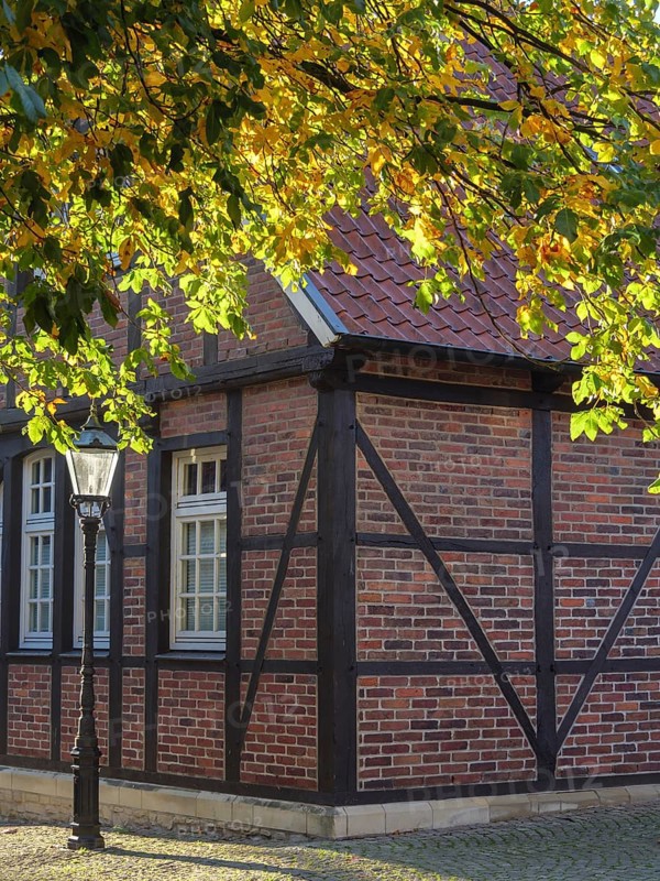 Half-timbered house with brick walls and lantern, surrounded by autumn leaves, nottuln, münsterland, germany