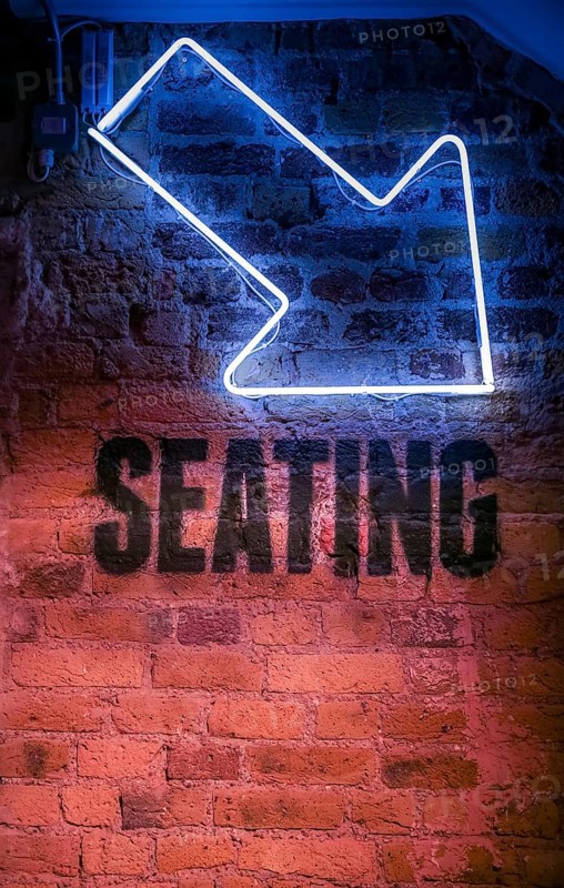 Seating sign with arrow pointing down