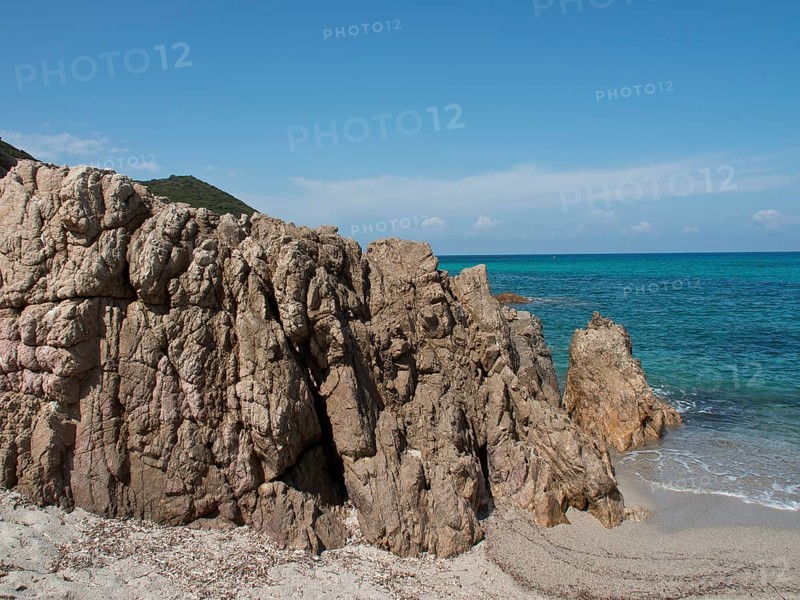 Rocky cliffs on a sandy beach with blue sea under a clear sky, ajaccio, corsica, france