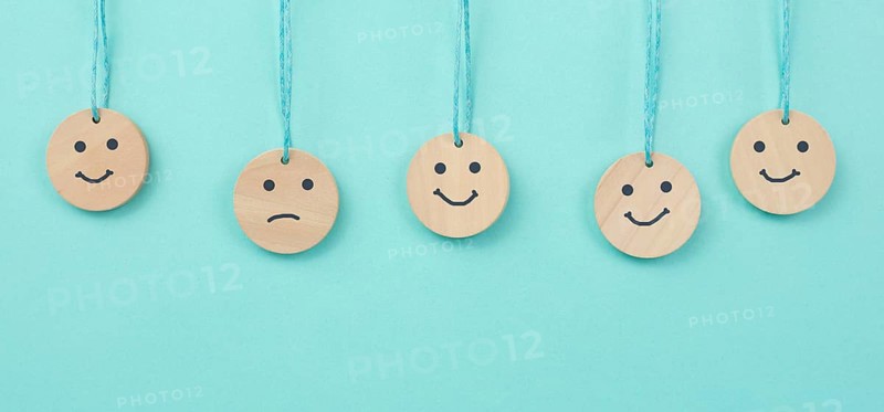 Happy smiling face spread happiness to sad faces, newton cradle concept, mental health and attitude, positive and negative mind, influence emotion, support and depression, pendulum balls
