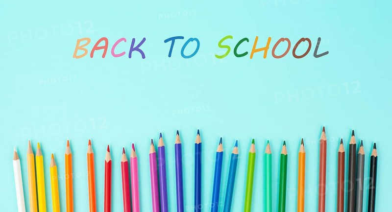 Color pencils collection in a row, back to school, drawing supplies, blue background with copy space