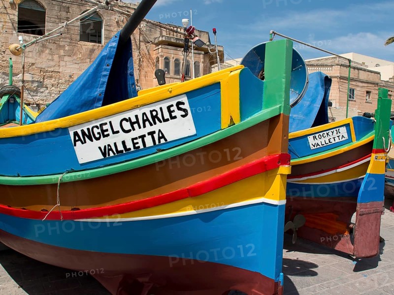 Multicoloured fishing boats parked in front of a historic building in Valletta, Malta, marsaxlokk, mediterranean sea, Europe