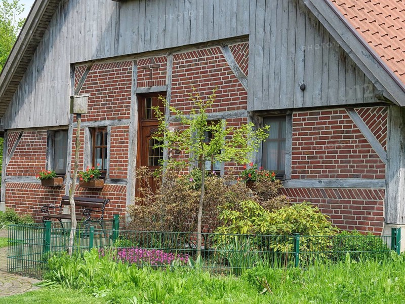 Traditional brick house with wooden elements, flower boxes and well-kept garden, marbeck, westphalia, germany
