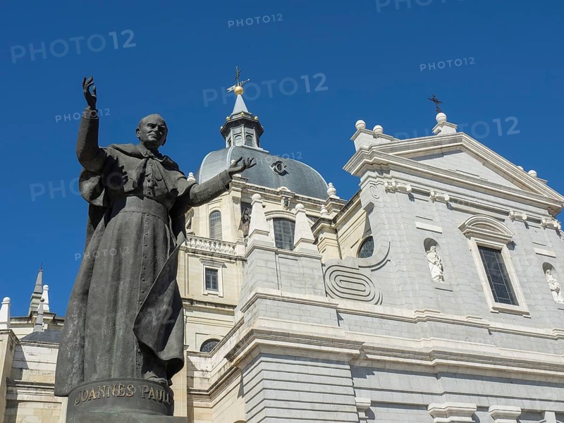 Statue of John Paul II in front of a church with a domed roof under a blue sky, Madrid, Spain, Europe