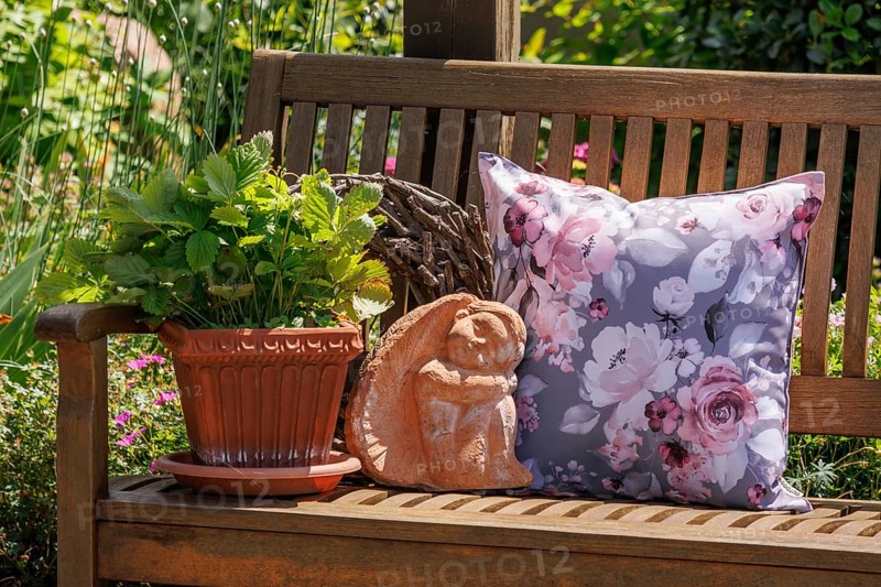 A decorative arrangement on a wooden bench with a floral patterned cushion, a terracotta pot and a small angel figurine, Borken, Münsterland, North Rhine-Westphalia, Germany, Europe