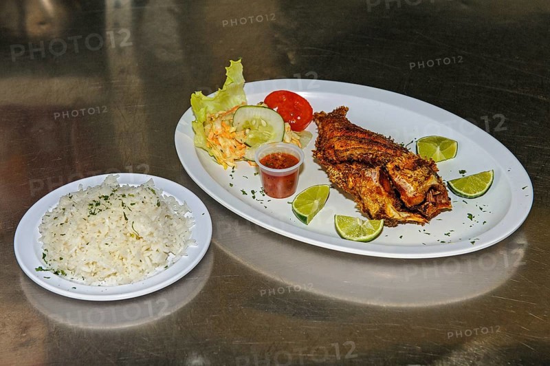 Pan-fried fish dish with Caribbean invasive lionfish (Pterois miles) prepared without head tail fins venomous spines spines ready to serve with lime, left side dish white cabbage salad, Caribbean, Leeward Islands, Netherlands Antilles, ABC Islands ABC Islands, Willemstad, Curaçao Curacao