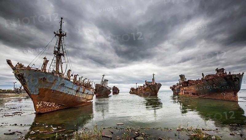 Rusty and decaying shipwrecks in the calm sea, surrounded by clouds and gloomy weather conditions, symbol photo ship graveyard, AI generated, AI generated