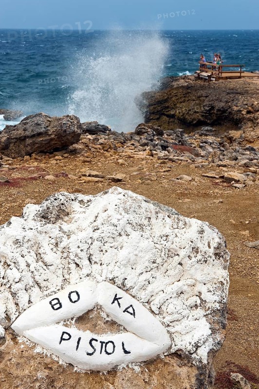 Viewpoint in excursion destination nature reserve Shete Boka National Park National Park with view of from rock crevice Boka Pistol spraying high fountain of sea water with white spray, in front stylised kissing mouth with lettering Boka Pistol, in the background Caribbean Sea, Caribbean, Windward Islands, Netherlands Antilles, ABC Islands ABC Islands, Curaçao Curacao