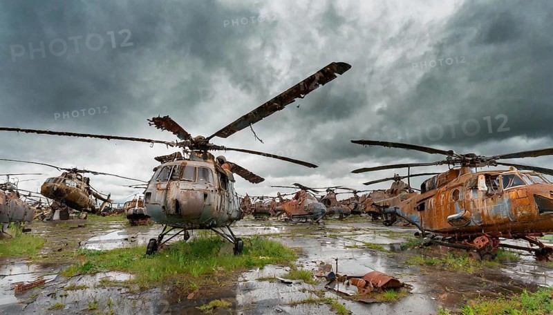 A group of rusty, abandoned helicopters on a wet and overgrown terrain under a cloudy sky, symbolic photo, AI generated, AI generated