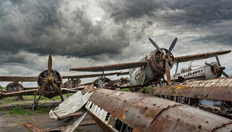 A weathered aircraft with rust and propellers, surrounded by other wrecks under a stormy sky, symbol photo, AI generated, AI generated