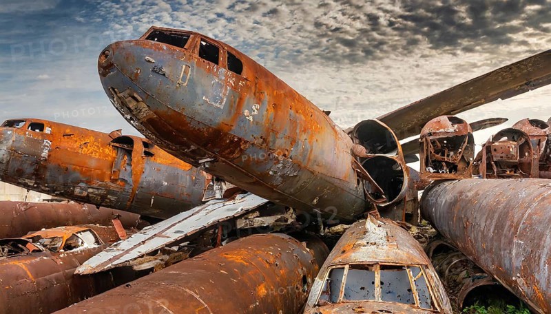 Collided and rusted aircraft wrecks on a scrap yard under a slightly cloudy sky, symbol photo, AI generated, AI generated
