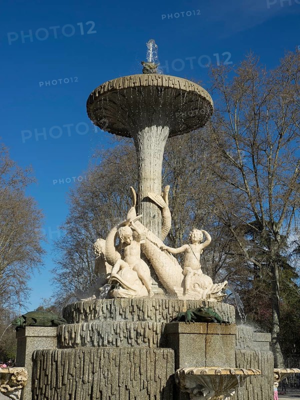 Large, artistic fountain with water jets and sculptures in the park under a blue sky, Madrid, Spain, Europe