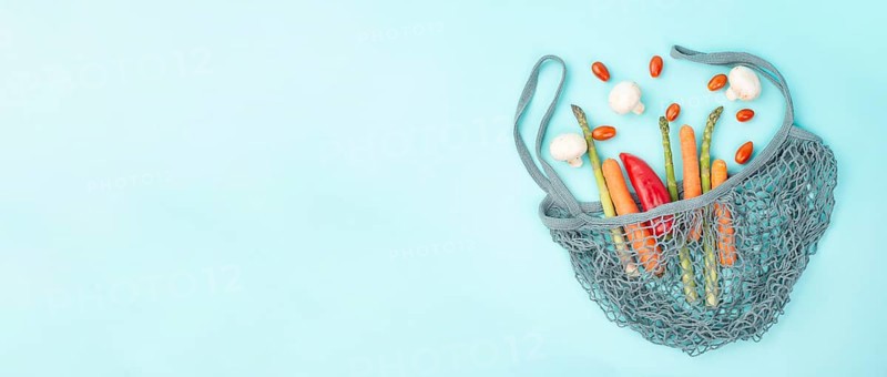Mesh bag with vegetables, shopping grocery, healthy food ingredients, asparagus sprout, mushrooms, carrots and tomatoes, zero waste