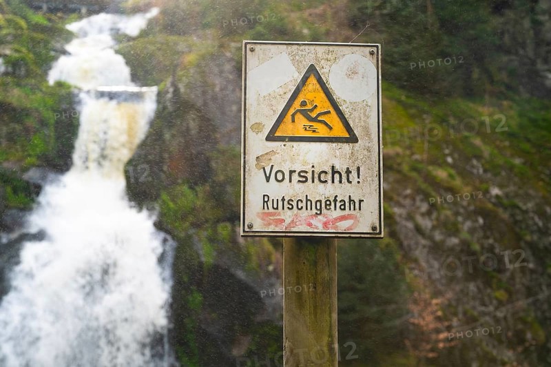 Slippery warning sign, Triberg waterfall in the Black Forest, highest fall in Germany, Gutach river plunges over seven major steps into the valley